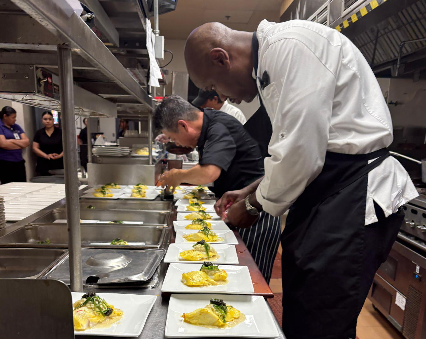 A chef at Asbury Communities preparing a dish in a kitchen. 